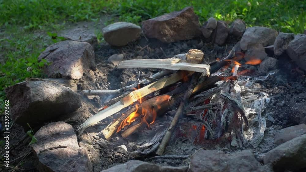 Kid lerning to arrange small bonfire outside in camping site. Kid lerning to arrange small bonfire outside in camping site.
