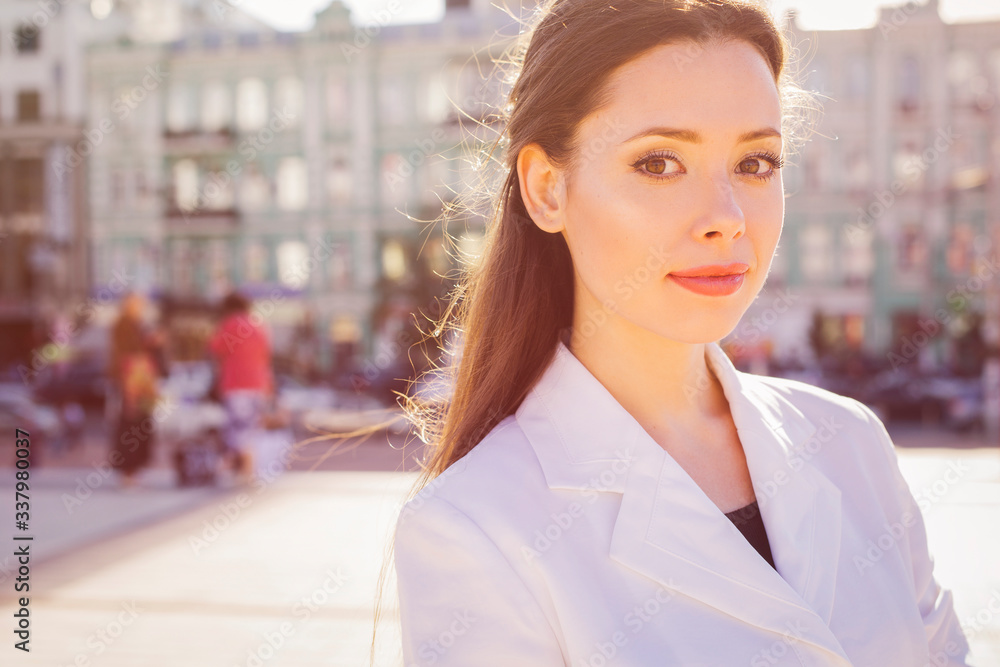 Beautiful brunette business woman in white suit and black t-shirt outdoors. copy space Beautiful brunette business woman in white suit and black t-shirt outdoors. copy space