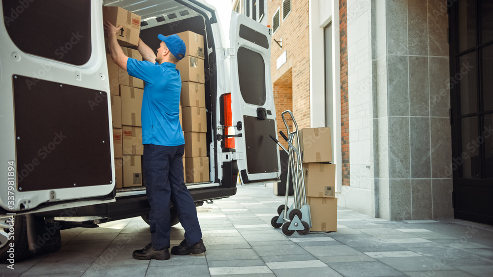 © Gorodenkoff - Delivery Man Uses Hand Truck Trolley Full of Cardboard Boxes and Packages, Loads Parcels into Truck / Van. Professional Courier / Loader helping you Move, Delivering Your Purchased Items Efficiently
