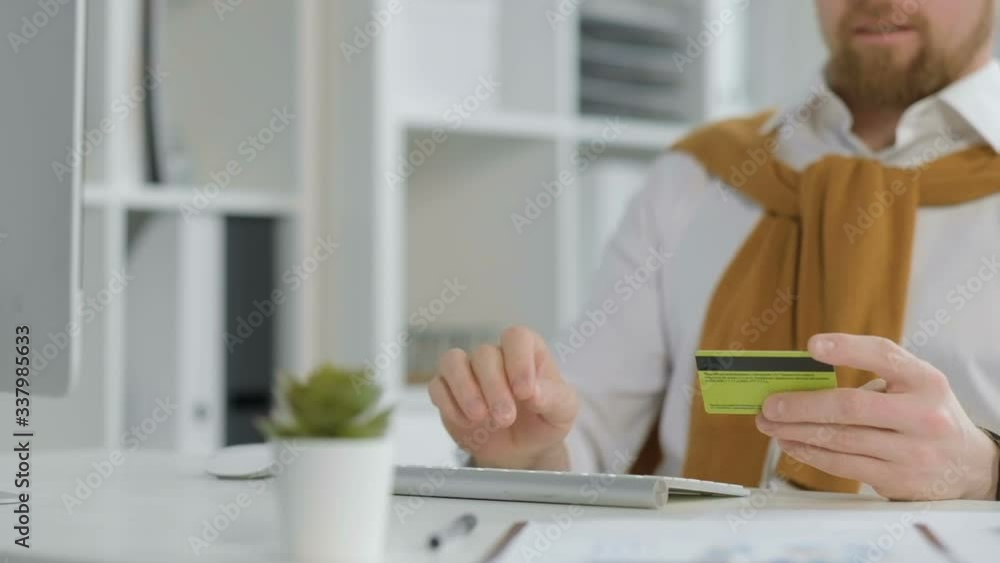 Man typing credit card information on keyboard Man typing credit card information on keyboard