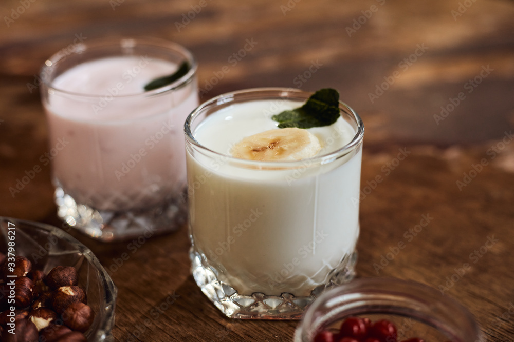 Yogurt with nuts on a wooden background. Side view. Summer food. Yogurt with nuts on a wooden background. Side view. Summer food.