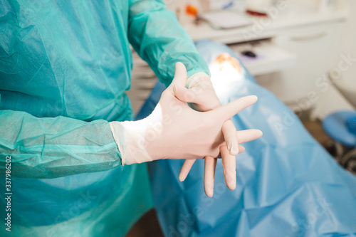 Surgeon putting on gloves before operation