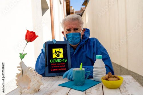 adult man dressed in protective suit showing a positive message written on a digital tablet