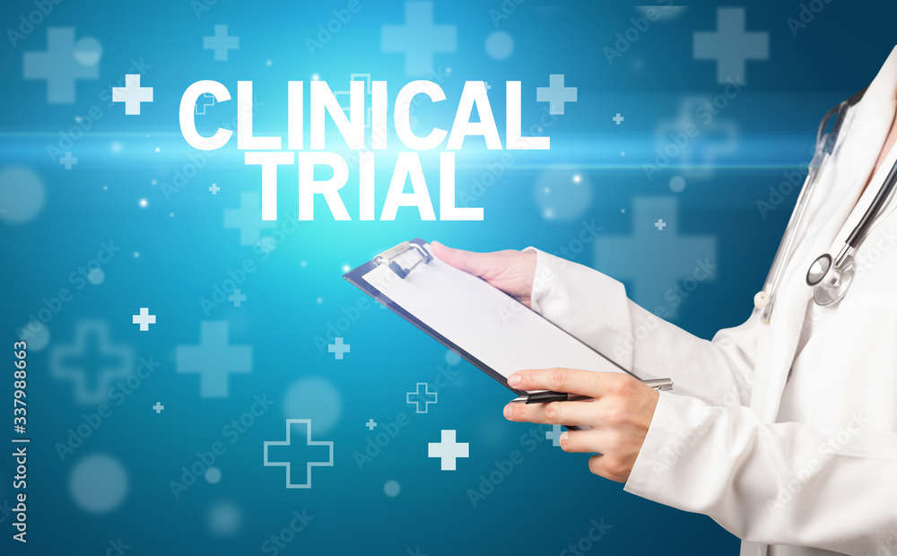 doctor writes notes on the clipboard with CLINICAL TRIAL inscription, first aid concept doctor writes notes on the clipboard with CLINICAL TRIAL inscription, first aid concept