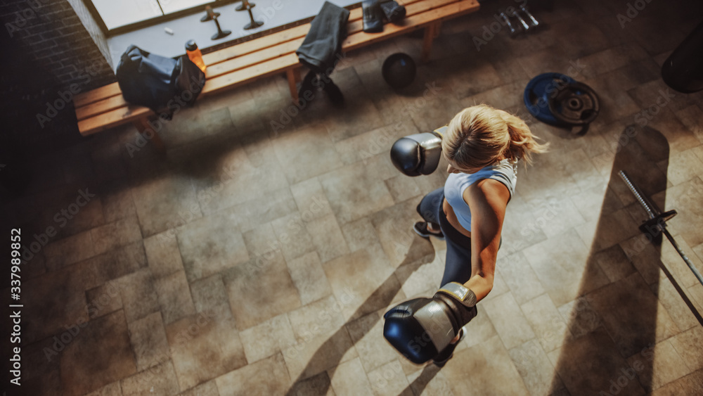 Φωτογραφία Professional Female Fighter Exercises Kicking and Punching Air while Wearing Sportswear and Fighting Gloves in the Hardcore Gym
