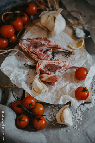 Raw fresh Lamb Meat ribs and seasonings on wooden background. BBQ cooking. Picnic ingredients