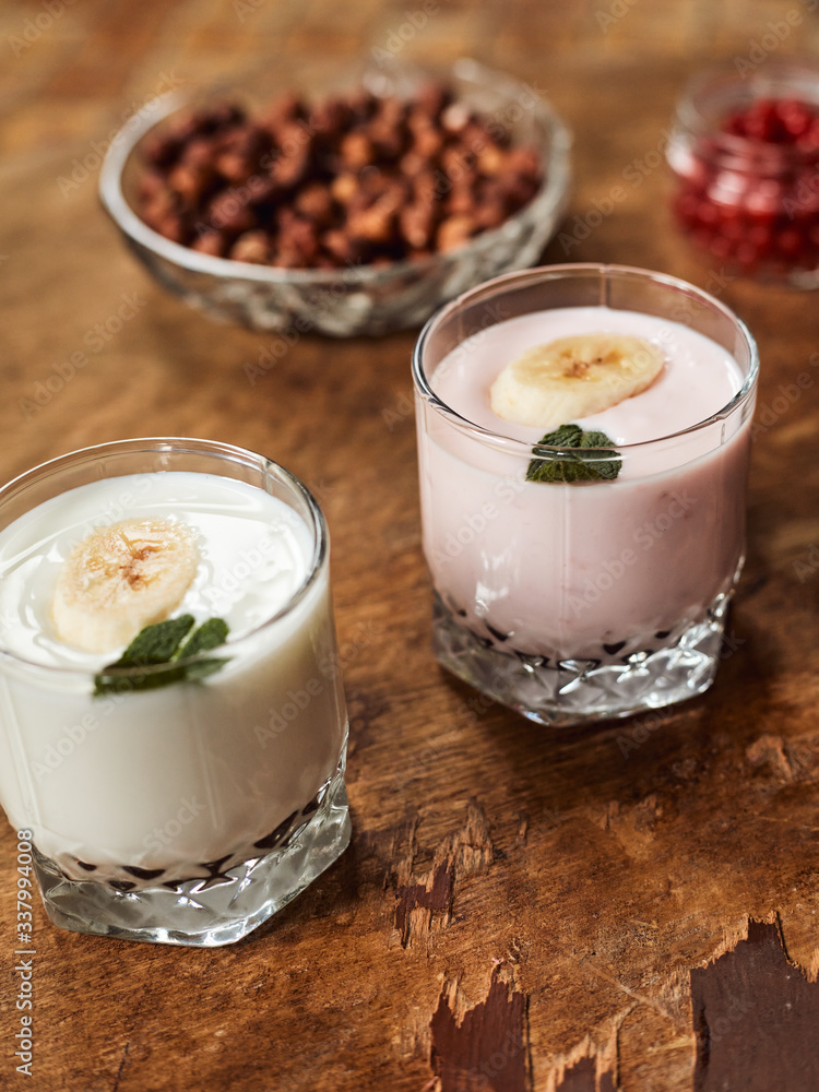Yogurt with nuts on a wooden background. Side view. Summer food. Yogurt with nuts on a wooden background. Side view. Summer food.