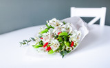 Bouquet of white alstroemeria flowers in lying on a white round table.