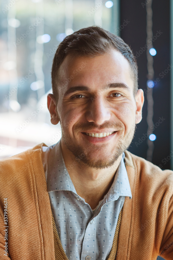 Fototapeta premium Portrait of a successful man who is in a cafe. The man smiles. Portrait close-up.