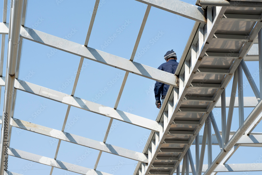 A man walking on the Light steel Truss and Frame construction.