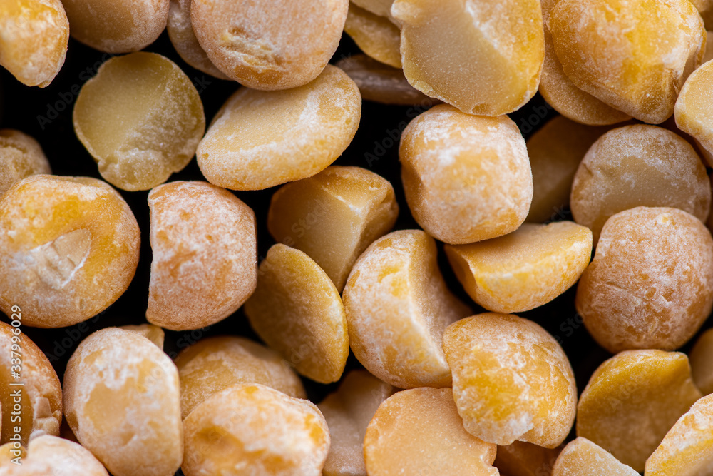 Obraz premium halves of dried crushed pea seeds on a black background
