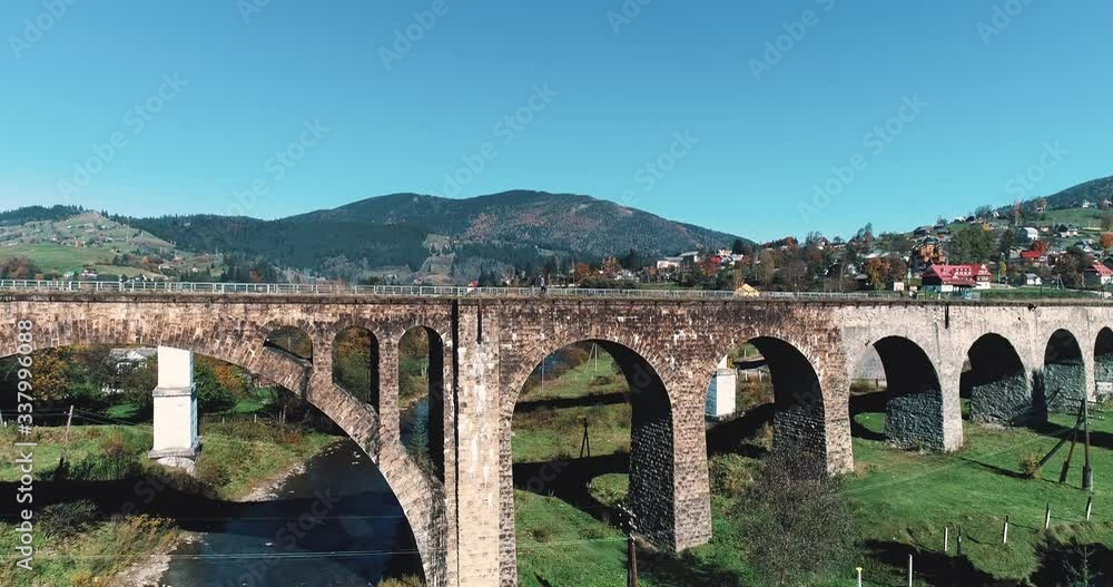 Girl goes through the old viaduct in the beautiful countryside Vorokhta village, Carpathian Mountains, Ukraine. Girl goes through the old viaduct in the beautiful countryside Vorokhta village, Carpathian Mountains, Ukraine.