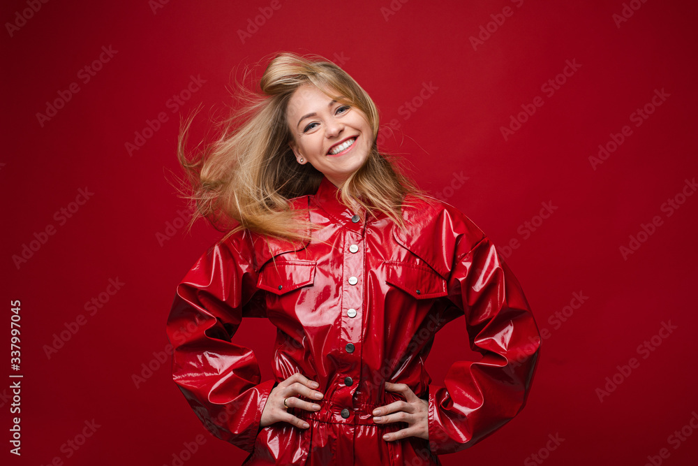Portrait of handsome caucasian female with long fair hair in red leather costume enjoys of her life Portrait of handsome caucasian female with long fair hair in red leather costume enjoys of her life