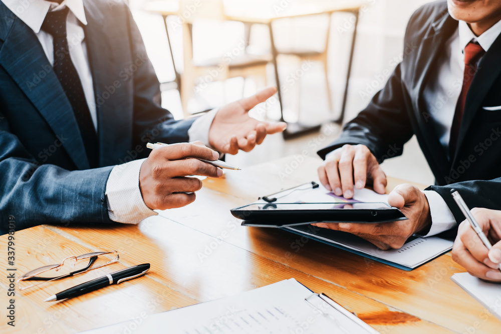Group of business people meeting together pointing to the tablet assess business profits. Group of business people meeting together pointing to the tablet assess business profits.