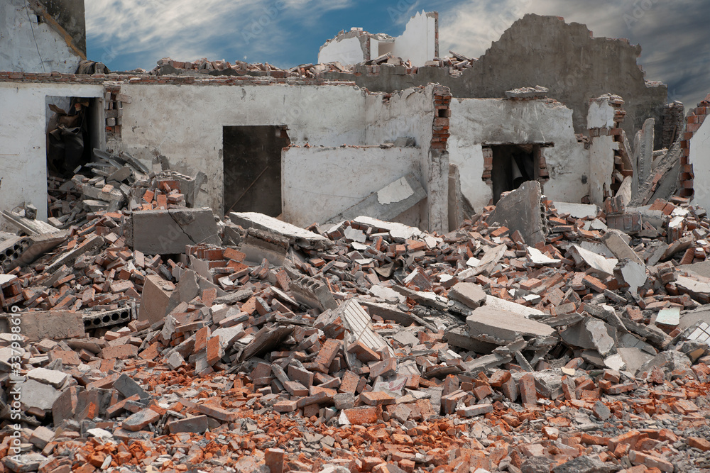 Demolishing site with ruined house and heap with bricks and other debris.