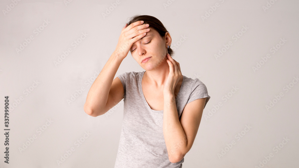 Young beautiful woman has headache, isolated on gray background Young beautiful woman has headache, isolated on gray background