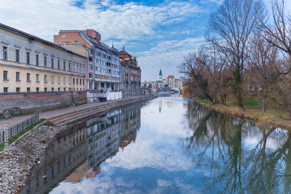 View upon the river Fast Crisu, in Oradea, with the reflections of antique buildings and winter nature. Image captured from The bridge of intellectuals