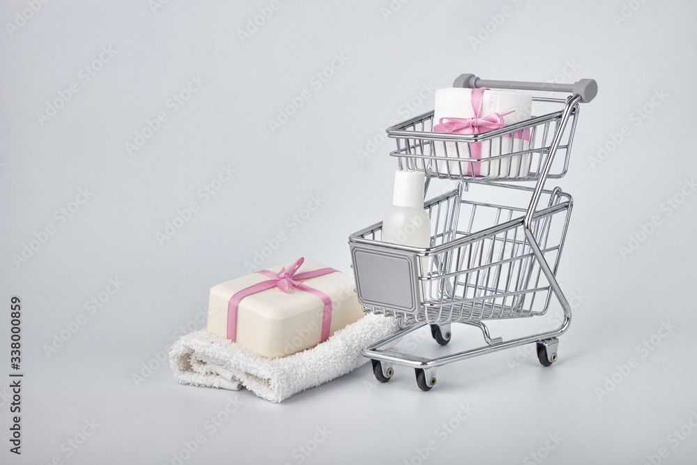 hygiene against viruses and bacteria concept, a bottle of hand sanitizer, toilet paper and soap inside a shopping basket symbol of highly sought-after products in times of self-isolation and quarantin
