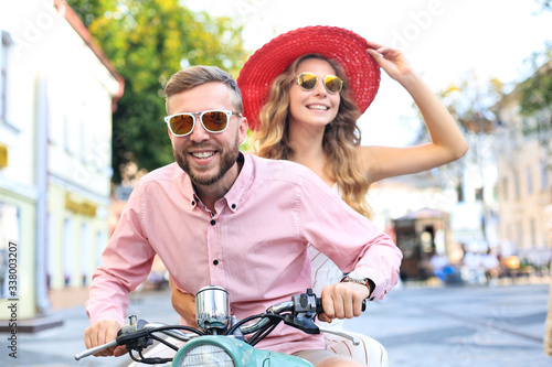 Young couple in love riding a motorbike. Riders enjoying themselves on trip. Adventure and vacations concept.