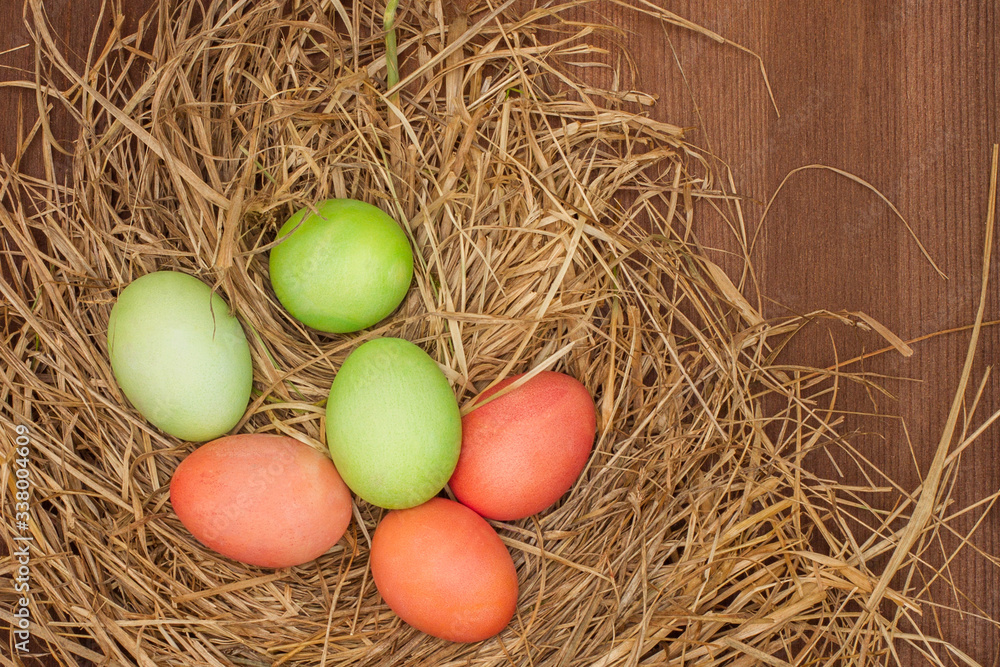 Easter, Easter eggs collection.
Easter eggs on a brown wooden table.
Easter eggs and hay. Orange and green eggs in the nest.
