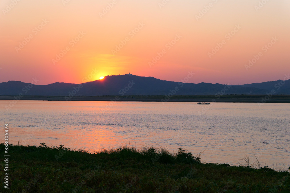 Obraz premium Boat on the river during sunset.