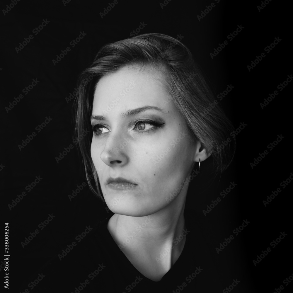 Fototapeta premium Black and white portrait of a girl on a black background. Powerful energy concept.