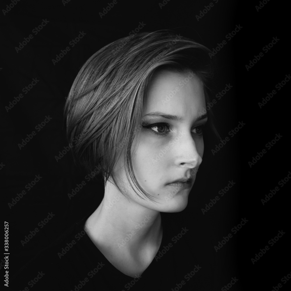 Black and white portrait of a girl on a black background. Powerful energy concept.