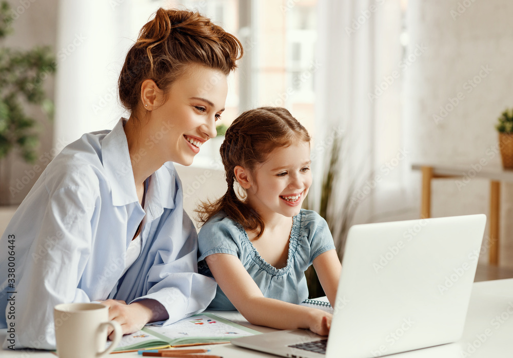 Happy girl with mother studying online at home Happy girl with mother studying online at home