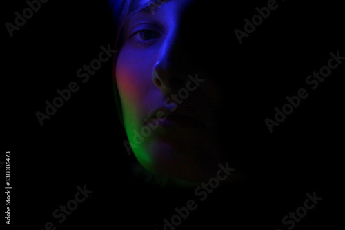 Dark portrait of a girl in color lighting
