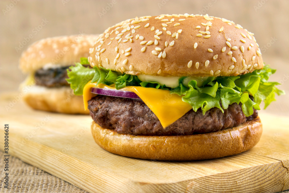 Homemade hamburgers on wooden board closeup