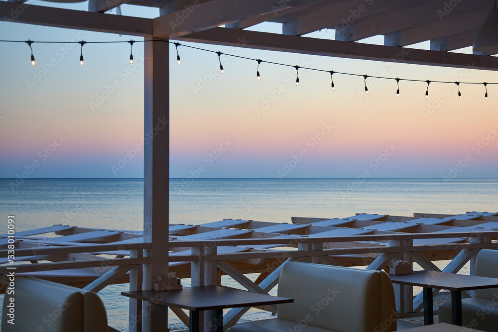 Cozy little cafe on the beach at sunset without visitors because of the coronavirus