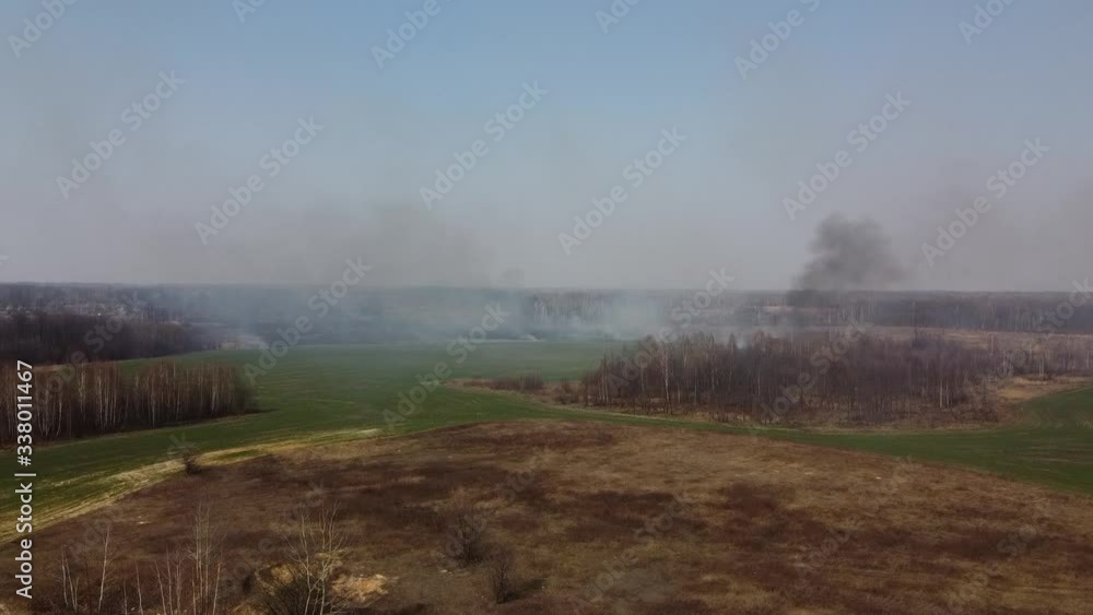 Forest and field fire. Dry grass burns, natural disaster. Aerial view. After the fire, the ground is covered with a black layer of burning and ash. Smoke field after wildfire Forest and field fire. Dry grass burns, natural disaster. Aerial view. After the fire, the ground is covered with a black layer of burning and ash. Smoke field after wildfire