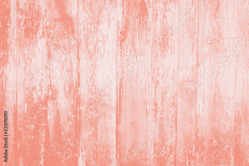 Old rustic wooden background toned in trendy color 2020 coral pink.