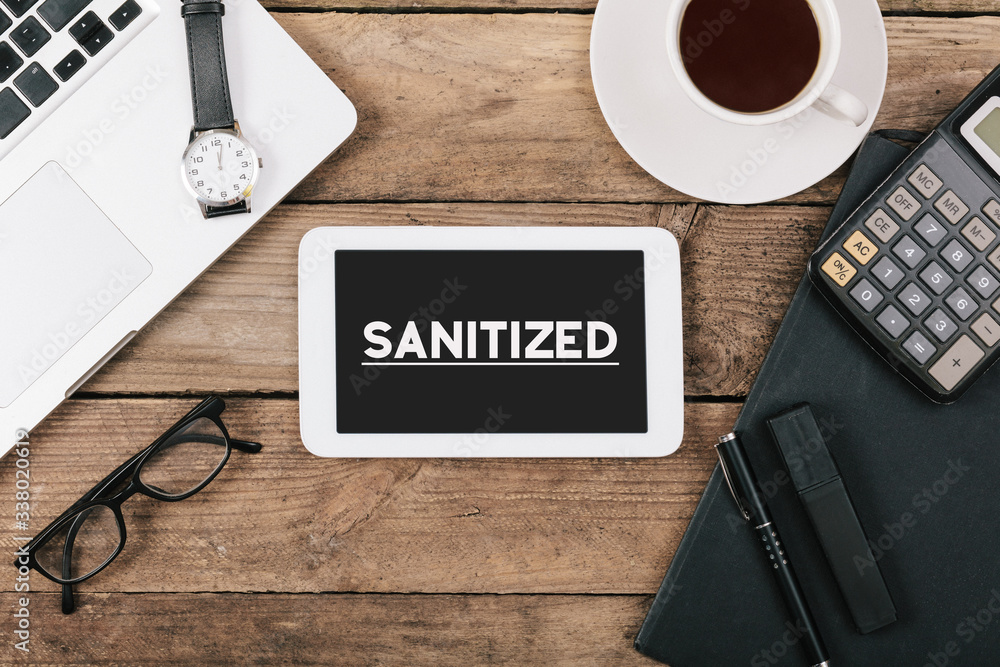 Sanitized word on tablet screen, corona virus pandemic buzwword headline Sanitized word on tablet screen, corona virus pandemic buzwword headline