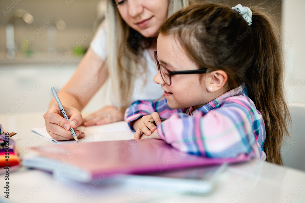 Beautiful young woman is helping her younger sister with homework. Beautiful young woman is helping her younger sister with homework.