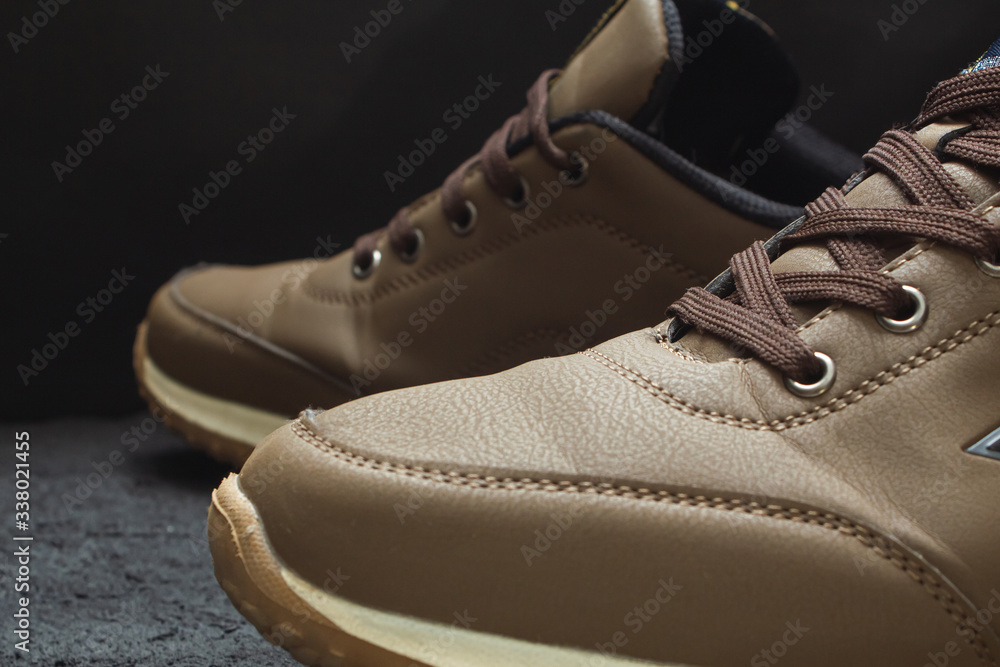 light brown leather sneakers on black concrete