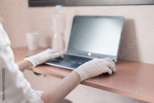 Doctor in the hospital analyzing test with her laptop . Young doctor writing the names of hospitalized patients with coronavirus. Work concept - Image