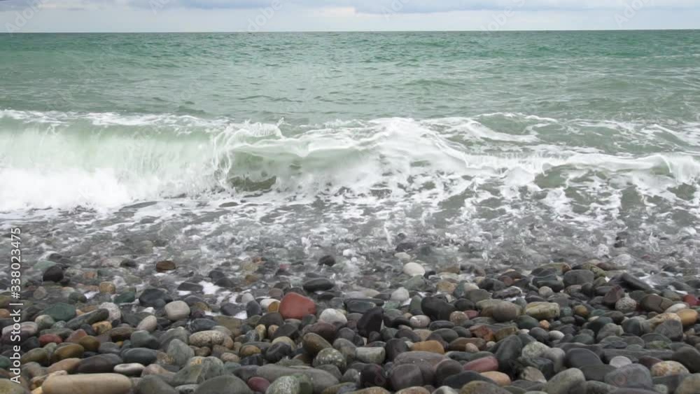 Sea waves roll on pebbles shore during a light storm slow motion slow motion Sea waves roll on pebbles shore during a light storm slow motion slow motion