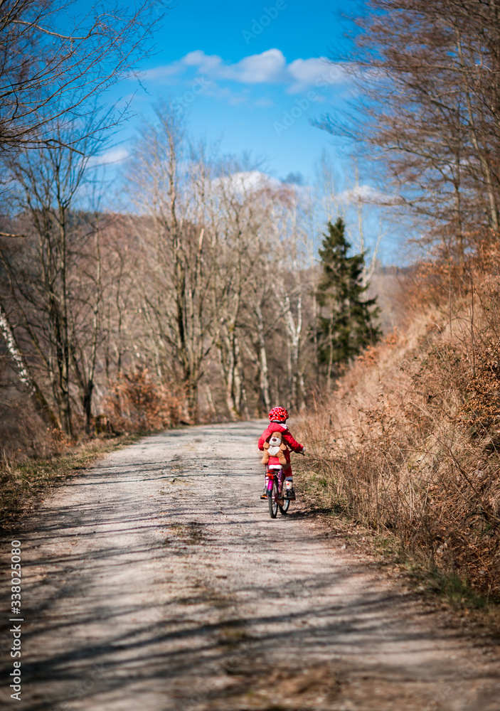 Five year old girl rides a pink bike in a forest in the mountains of German Harz Five year old girl rides a pink bike in a forest in the mountains of German Harz