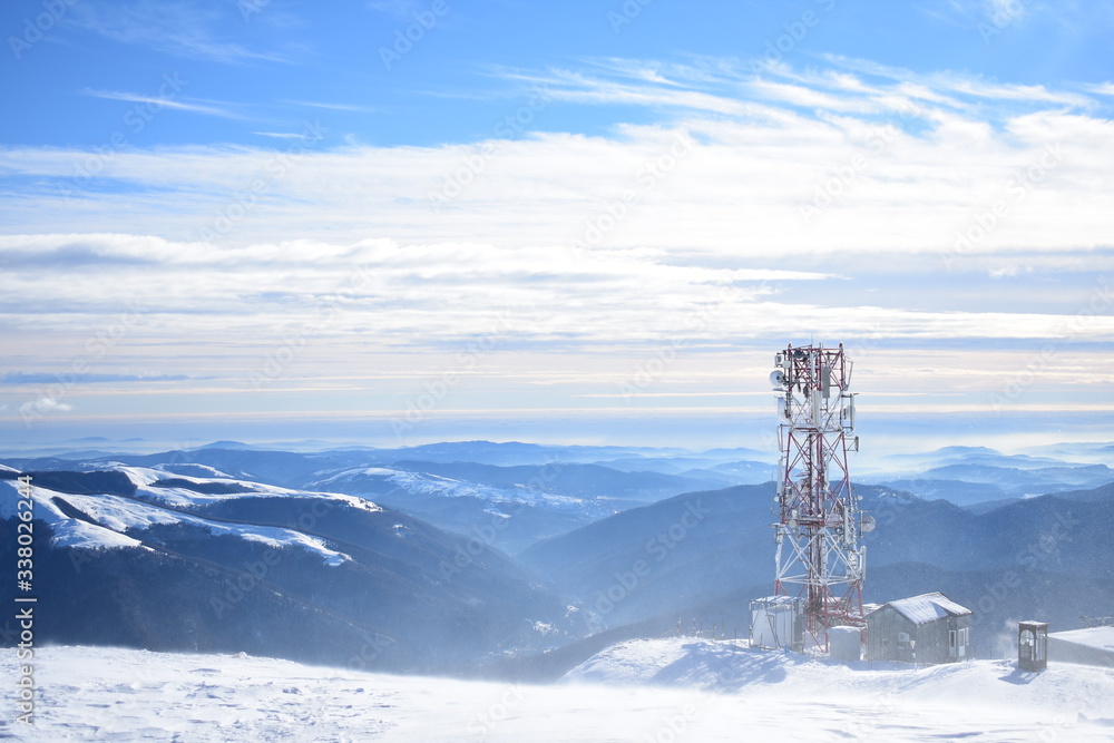 Clouds in snowy mountain tops with tower in winter in Busteni Romania Clouds in snowy mountain tops with tower in winter in Busteni Romania