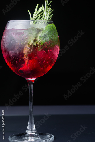 .red refreshing alcoholic cocktail made from cherry juice decorated with mint and cinnamon