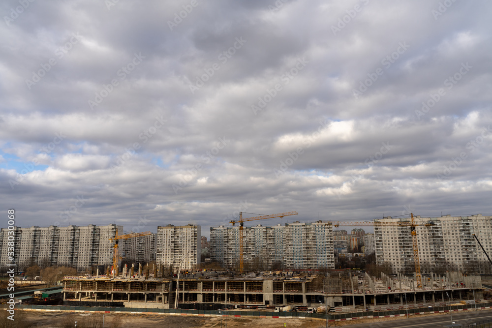 aerial view of a residential area of ​​the city with gray volumetric clouds and a construction site