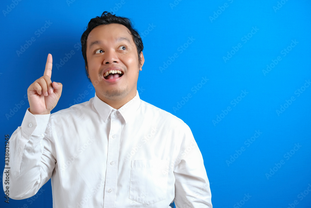 an asian office worker looking happy to find a brilliant idea an asian office worker looking happy to find a brilliant idea