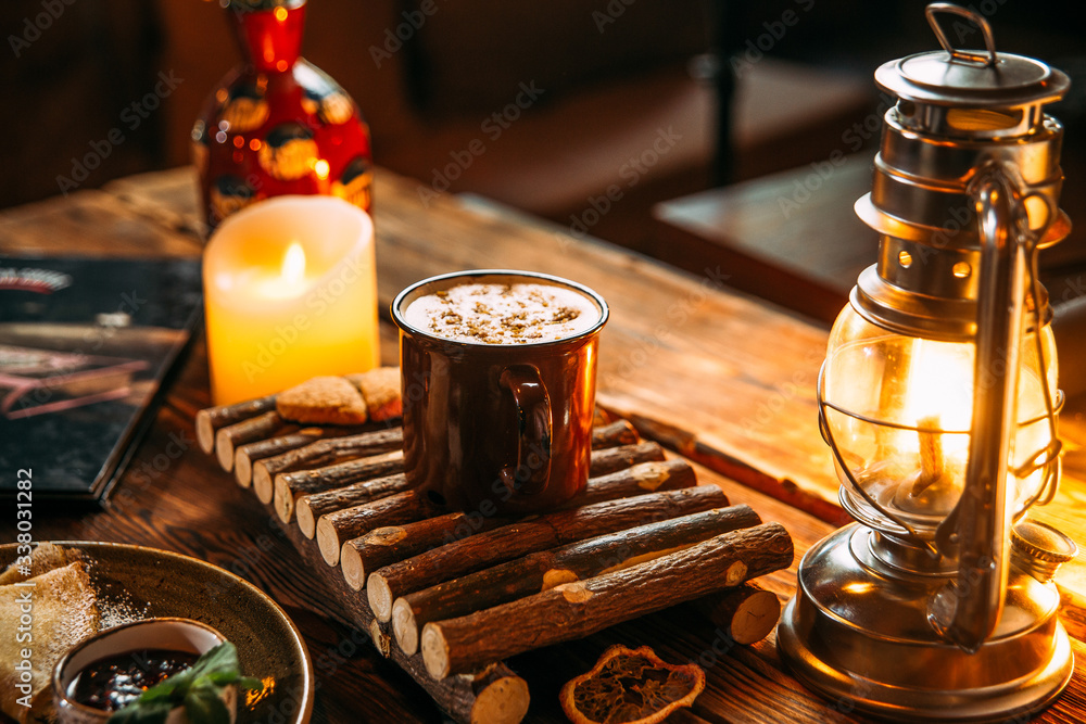 Side view on delicious warming cappuccino coffee with cinnamon in a mug on the wooden board, horizontal format Side view on delicious warming cappuccino coffee with cinnamon in a mug on the wooden board, horizontal format