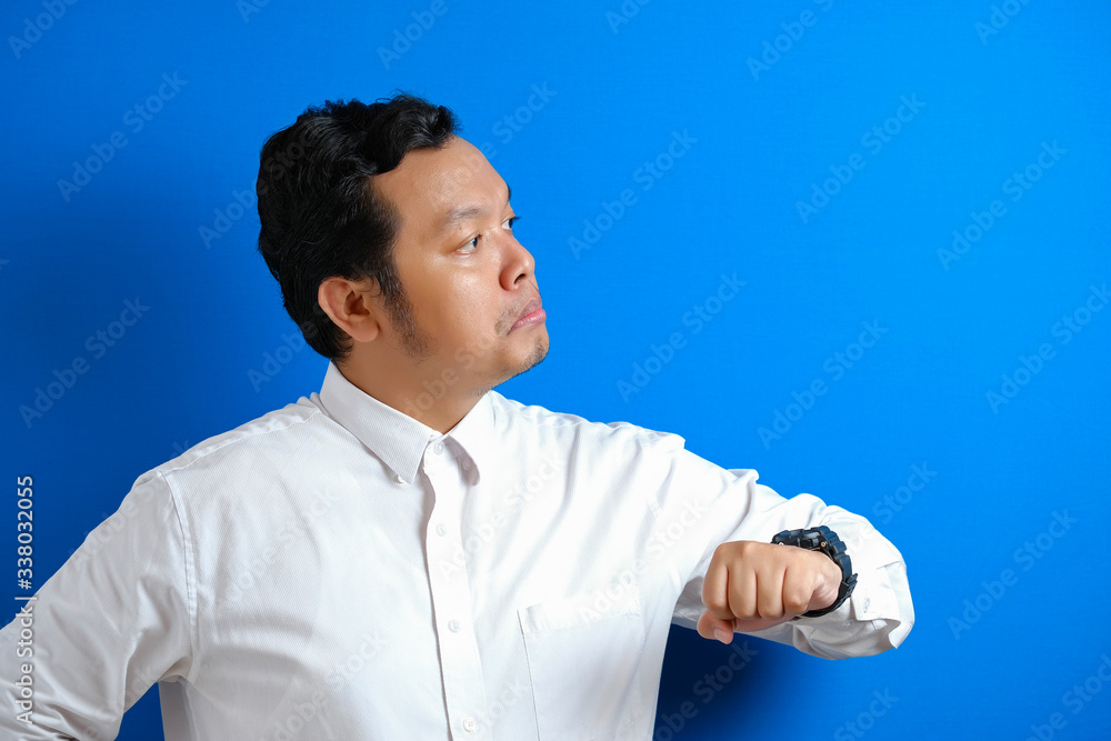Asian businessman wearing white shirt check time on his wrist watch Asian businessman wearing white shirt check time on his wrist watch
