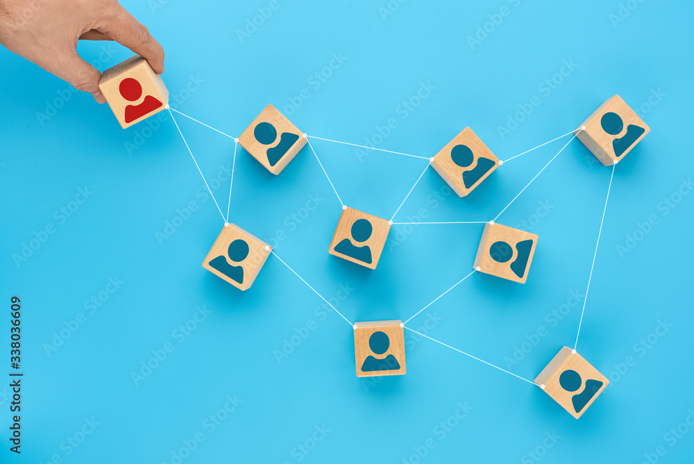 Concept of social distance for protection against COVID-19 coronavirus. A man's hand removes a wooden cube with the image of a sick person, the lines between the blocks reflect social interaction Concept of social distance for protection against COVID-19 coronavirus. A man's hand removes a wooden cube with the image of a sick person, the lines between the blocks reflect social interaction