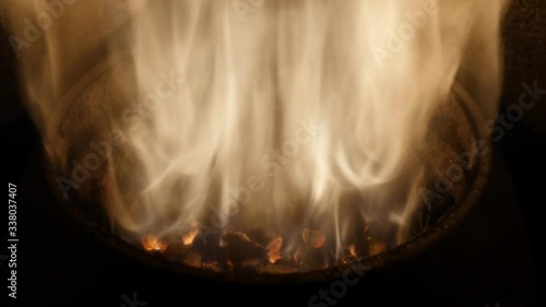 closeup image of burning wood pellets with fire flames. Wood stove heating with in foreground wood pellets - economical heating system concept