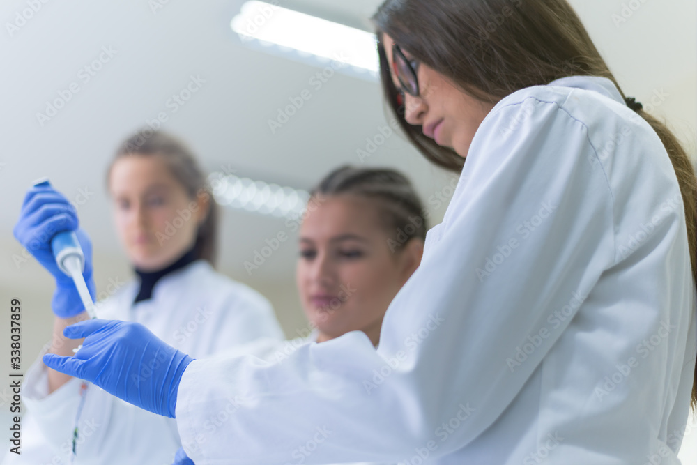 Group of  Laboratory scientists working at lab with test tubes, test or research in clinical laboratory.Science, chemistry, biology, medicine and people concept.