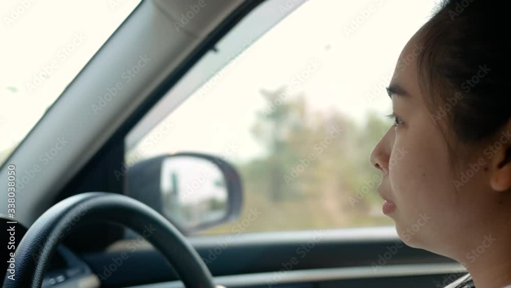 Young woman driving a car, hand put on the black steering wheel and looking forward drive with caution. Young woman driving a car, hand put on the black steering wheel and looking forward drive with caution.