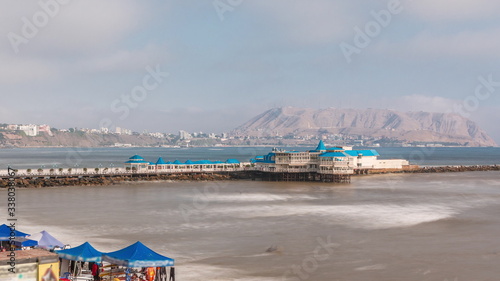 Aerial view of the Pier taken from the pebble beach. Restaurant is located at the end of the pier timelapse. Miraflores, Lima, Peru © neiezhmakov